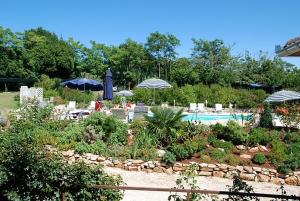 um jardim com uma piscina e guarda-sóis e cadeiras e uma piscina em Ferienwohnung IUSAF-123-1 em Savudrija