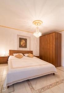 um quarto com uma cama e um lustre em Ferienwohnung IUSAF-123-1 em Savudrija