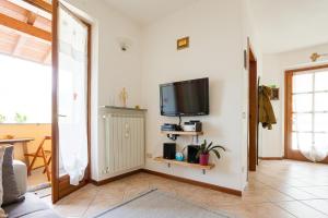 a living room with a flat screen tv on a wall at La Cà Dol Sùl in Orezzo