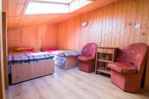 a room with two beds and a table and chairs at Domki Boja in Swarzewo