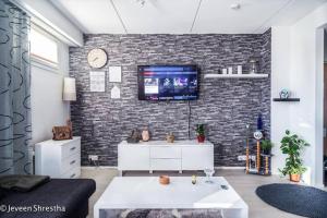 ein Wohnzimmer mit einem TV an einer Backsteinwand in der Unterkunft Amazing Apartment Toppilansaari in Oulu