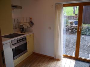 a kitchen with a stove top oven next to a window at "Heckenrose" in Ilsenburg