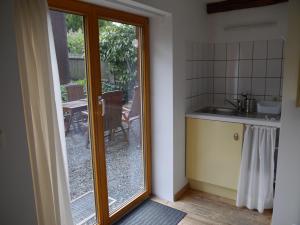 a kitchen with a sliding glass door leading to a patio at "Heckenrose" in Ilsenburg