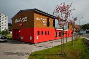 ein rotes Gebäude mit einem Fast-Food-Restaurant in der Unterkunft Penzion Kuželna in Trutnov