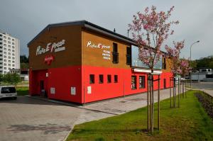 a red building with a fast food restaurant at Penzion Kuželna in Trutnov