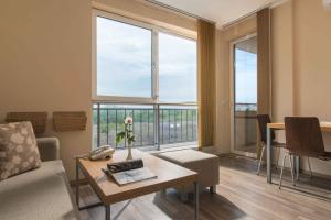 ein Wohnzimmer mit einer Couch und einem Tisch und Fenstern in der Unterkunft Obzor Beach Resort in Obsor