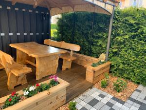 une table et un banc en bois sur une terrasse en bois dans l'établissement Studio cosy au centre de Couvet, à Couvet