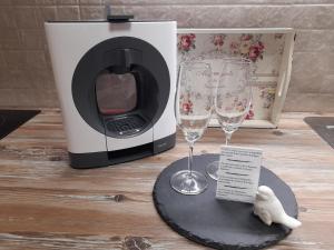 a microwave and two wine glasses on a table at Cantinho do Burgau in Burgau