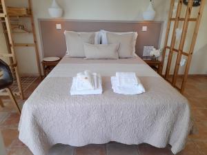 a bedroom with a bed with towels on it at Cantinho do Burgau in Burgau