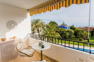 balcón con mesa, sillas y vistas al océano en Suite Bora Bora, en Marbella