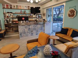 a living room with a couch and chairs and a counter at Hotel Adria B&B - Colazione fino alle 12 in Misano Adriatico