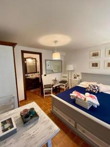 a bedroom with a blue bed and a table at Il Poggio degli Ulivi in Collicello