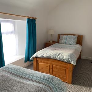 1 dormitorio con 2 camas individuales y ventana en Driftwood House, en Portaferry