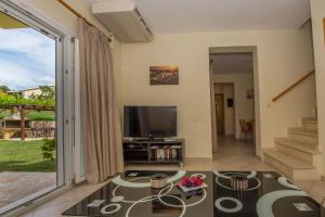 sala de estar con TV y ventana grande en Villas Porto Odysseas Afionas Corfu, en Afionas