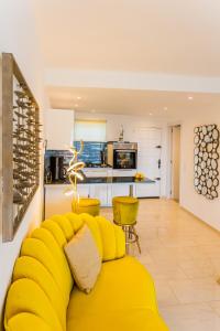 un sofá amarillo en una sala de estar con cocina en Suite Bora Bora, en Marbella