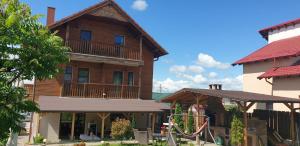 a wooden house with a playground in front of it at Casa Paduricea in Dezmir