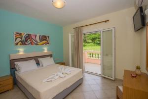 1 dormitorio con 1 cama y puerta corredera de cristal en Villas Porto Odysseas Afionas Corfu, en Afionas