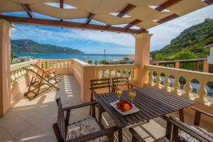balkon ze stołem i krzesłami oraz widokiem na ocean w obiekcie Villas Porto Odysseas Afionas Corfu w mieście Afionas