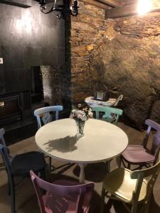 una mesa con sillas y un jarrón de flores. en El Refugio del Alquimista - Casa rural - Médulas, en Puente de Domingo Flórez