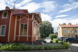 a small red house on the side of a street at Center Orange house in Cēsis