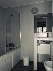 uma casa de banho com um lavatório, um WC e um espelho. em Hôtel Le Pescadou em Argelès-sur-Mer