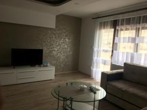 a living room with a couch and a tv and a table at Zlatarska čarolija in Nova Varoš
