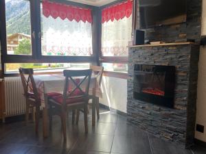une salle à manger avec une table et une cheminée dans l'établissement Chamonix centre - WIFI - Parking - Rés Aiguille du midi, à Chamonix-Mont-Blanc
