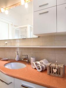 ein Badezimmer mit einem Waschbecken und einer Theke mit Handtüchern in der Unterkunft CLARE HOUSE per una vacanza "CHIC" in Porto Recanati