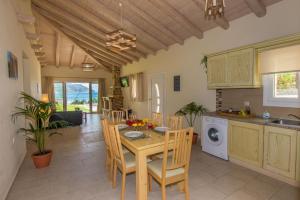 uma cozinha e sala de jantar com mesa e cadeiras em Villas Porto Kamini Afionas Corfu em Afionas