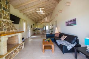 a living room with a couch and a fireplace at Villas Porto Kamini Afionas Corfu in Afionas