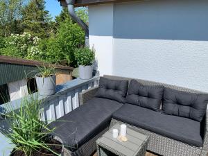 a black couch sitting on a balcony with a table at Henkieker - ländliche Ferienwohnung mit Stil in Fehmarn