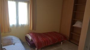 una piccola camera da letto con un letto e una finestra di Appartement Saint Raphael Centre a Saint-Raphaël