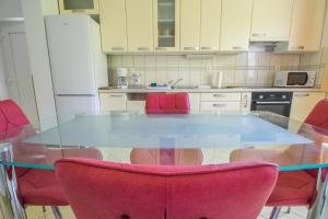 a kitchen with a glass table and pink chairs at Apartments Joseph and Mary in Trogir