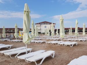 a group of lounge chairs and umbrellas on a beach at Hotel Laguna in Mangalia