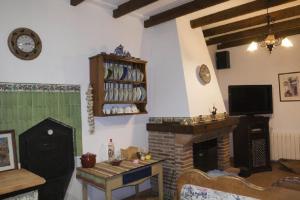 a living room with a fireplace and a tv at Huerta Solana in Castril