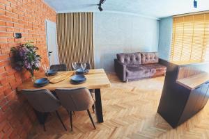 a living room with a wooden table and a couch at Studio Loft Winnica Sopel in Ziewanice
