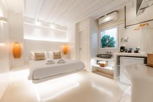 a white bedroom with a bed and a sink at Anastasia's Visage Stylish Accommodation Rooms City Centre Mykonos in M&yacute;konos City