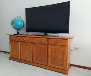 a television on a wooden cabinet with a globe on it at Casa Érika in Puerto del Rosario