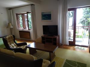 een woonkamer met een televisie en een tafel bij Vuksanovic Apartment in Herceg-Novi