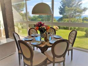 a dining room table with chairs and a large window at Sierra Bermeja in Estepona