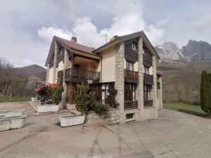a apartment building with a parking lot in the mountains at Hotel Cumbres de Valdeón in Posada de Valdeón
