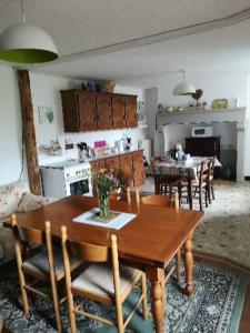 Il comprend une cuisine et une salle à manger avec une table et des chaises en bois. dans l'établissement Farm cottage, à Les Riffes