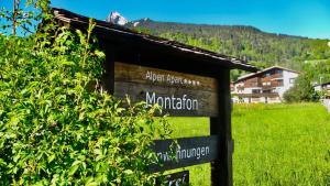 a sign in a field with a mountain in the background at AlpenApart Montafon - Haus Engstler in Schruns-Tschagguns