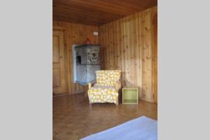 een woonkamer met een stoel en een oven bij Alpia 26 - Zwei Zimmerwohnung in traditionellem Walliser Haus in Gasenried