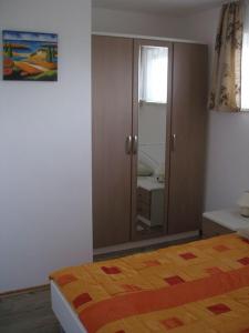 ein Schlafzimmer mit einem Bett und einem großen Spiegel in der Unterkunft Apartment in Mošcenicka Draga with sea view, balcony, air conditioning, Wi-Fi (4772-1) in Mošćenička Draga