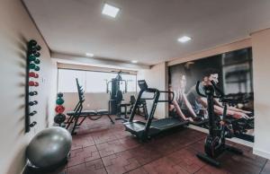 a gym with two people exercising on tread machines at Manaíra Apart Hotel in João Pessoa