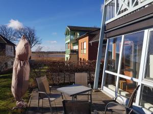 eine Terrasse mit Stühlen, einem Tisch und einem Sonnenschirm in der Unterkunft Fewo 2 im Fischerhaus mit Terrasse in Ostseebad Sellin