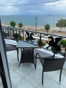 Un balcón con mesas y sillas y vistas al océano. en Argo en Skala