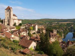 een klein dorpje met een kerk en een meer bij Maison Ustou46 in Cahors