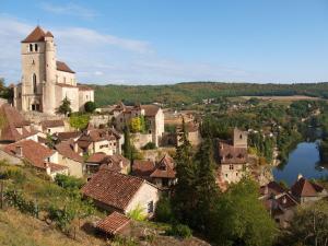 a small village with a church and a lake at Maison Ustou46 in Cahors